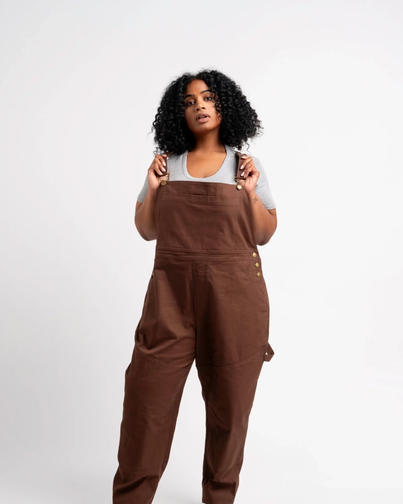 Front of a model wearing a size 6X get dirty workwear overall in espresso by alder apparel. | dia_product_style_image_id:318948